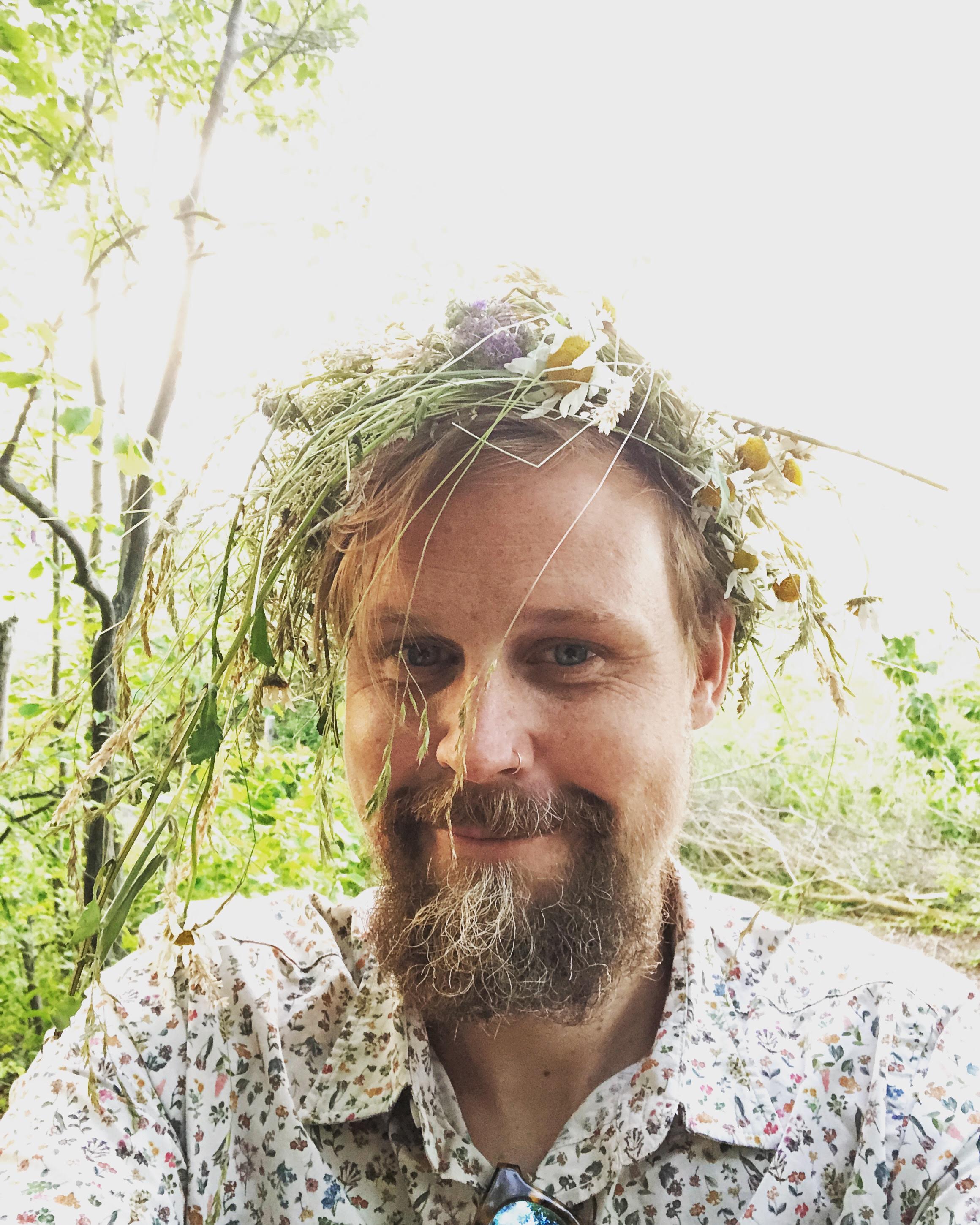 Michael wearing a flower crown at a Swedish folk music midsummer celebration